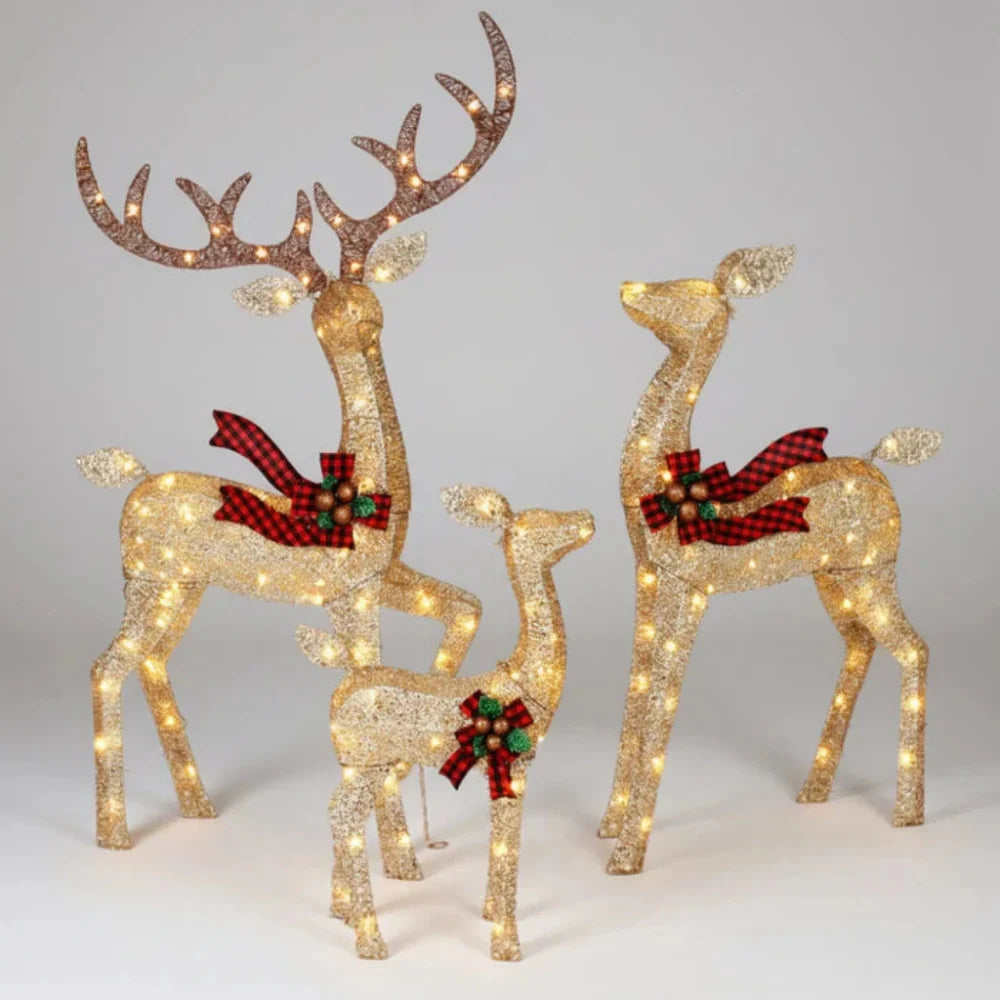 Light up reindeer family set of 3 glowing on a front lawn at Christmas