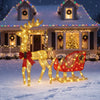 Lighted reindeer and sleigh outdoor Christmas decoration on a front lawn