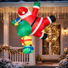 Christmas inflatable climbing Santa lit up on a house at night