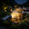 Solar spotlight highlighting a garden water feature at night