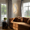 LED wall art feather wall light, beside a living room window