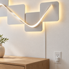 Geometric LED wall art plugged into a wall outlet by USB, cable running down to the outlet
