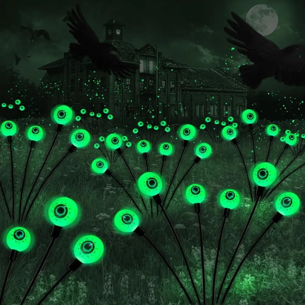 Green solar eyeball lights in a garden at night