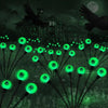 Green solar eyeball lights in a garden at night