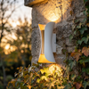 LED wall washer sconce on an ivy covered garden wall raking light across the stone