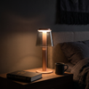 Mushroom table lamp lit on a bedside table in a dark bedroom at night