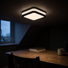 Square black flush mount ceiling light on a neutral setting in a home study at dusk