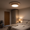 Large wood tone travertine flush mount ceiling light in a bedroom at night