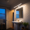 Retractable LED bathroom vanity light on an extended rod above a guest bathroom mirror
