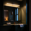 Two-tone gold and black linear vanity light bar above a dark green half bath mirror