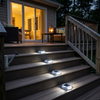 White solar step lights on composite deck stairs at dusk