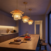 Three small bamboo pendants in a row over a kitchen island at dusk