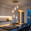 Gold 5-light crystal chandelier cluster over a dark kitchen island at blue hour