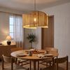 Yellow-brown natural rattan pendant light over a round oak dining table