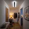 Black slim linear LED ceiling bar lighting a home entry hallway
