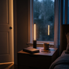 Black cordless touch table lamp on a nightstand by a rainy window