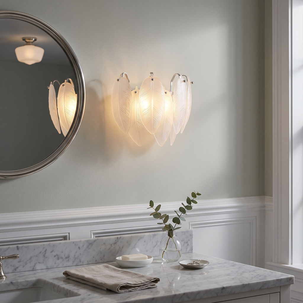 Nickel glass feather wall sconce glowing beside a powder room mirror