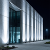 Cool white long throw wall washer beams on a modern concrete building