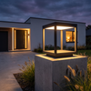 Modern open frame square pillar lantern glowing on a concrete gate post