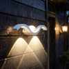White wave outdoor wall sconce glowing in the rain, IP65 weatherproof
