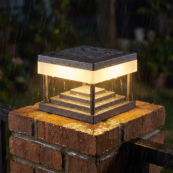 Solar pillar post cap light shedding rain on a brick gate pillar at night