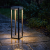 Modern black pathway light beside a slate walkway in steady rain