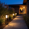 Three garden bollard lights lighting the way to a family at their door