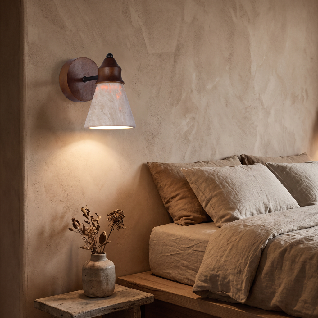 Travertine and wood wall sconce casting a warm pool of light in a wabi-sabi bedroom