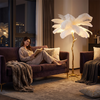 Woman reading at night in the warm glow of the feather floor lamp