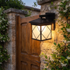 Frosted glass solar wall sconce glowing on a stone courtyard wall