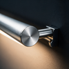 Close-up of the brushed aluminum cylinder and wall arm of the vanity bar light