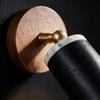 Close-up of the marble ring, wood backplate and brass pivot on the black spotlight wall light