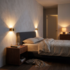 Half cylinder up down wall sconces in brass, a pair beside a bed