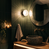 Ribbed glass dome wall light beside a bathroom mirror