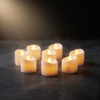 Flameless LED tea light candles glowing on a dark slate surface