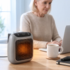 Small desk heater on a home office desk beside a coffee mug