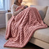 Pink plush throw blanket over a woman's lap on a sofa