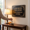 Black embossed blessing sign above an entry console table