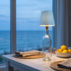 Bottle lamp, light blue shade, by an ocean view window