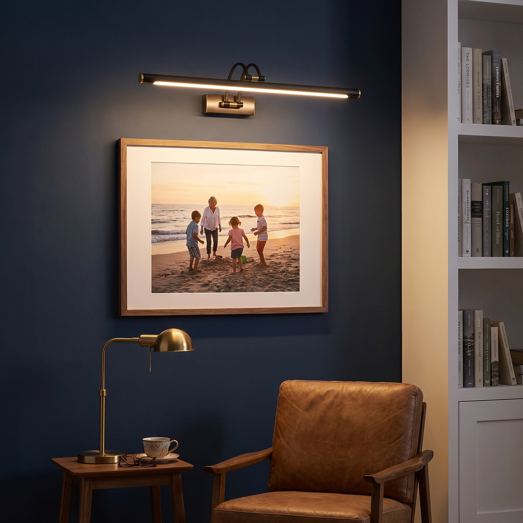 Black picture light above a framed family beach photo in a navy home study