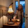 Witch hat lamp lit on an entryway console beside a Halloween candy bowl