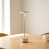 Cordless desk lamp, silver aluminum rechargeable lamp on a dining table