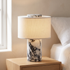 Travertine table lamp, black marble base with fabric shade, cordless, on a nightstand