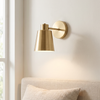 Cordless gold cone wall sconce, rechargeable with remote, beside a bed