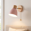 Pull chain wall sconce, pink, Scandinavian wall light beside a bed