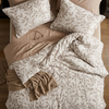Floral duvet cover set on an unmade bed, Beige