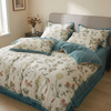 Floral duvet cover set on an unmade bed, Blue
