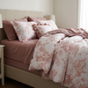 Floral duvet cover set on an unmade bed, Pink