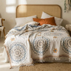 Boho cotton gauze bedspread on an unmade bed