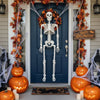Full body posable Halloween skeleton hanging on a front door